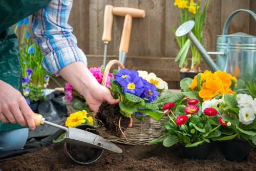 Worker using landscaping equipment with proper safety precautions